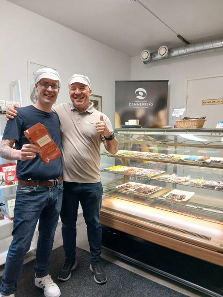 Marko-Iso Kungas (Dammenberg) und Kim-Rudolf Mayer (Schoko-Wunderland.de) sind auf dem Foto vor einer Verkaufstheke mit Dammenberg-Schokoladen