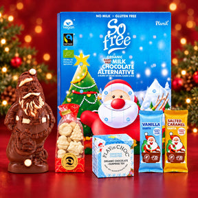 Genießer-Set vor rotem Hintergrund mit lose verpackten weißen Weihnachtsfiguren